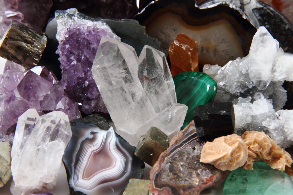 A variety of colored gems, including clear quartz and purple amethyst.